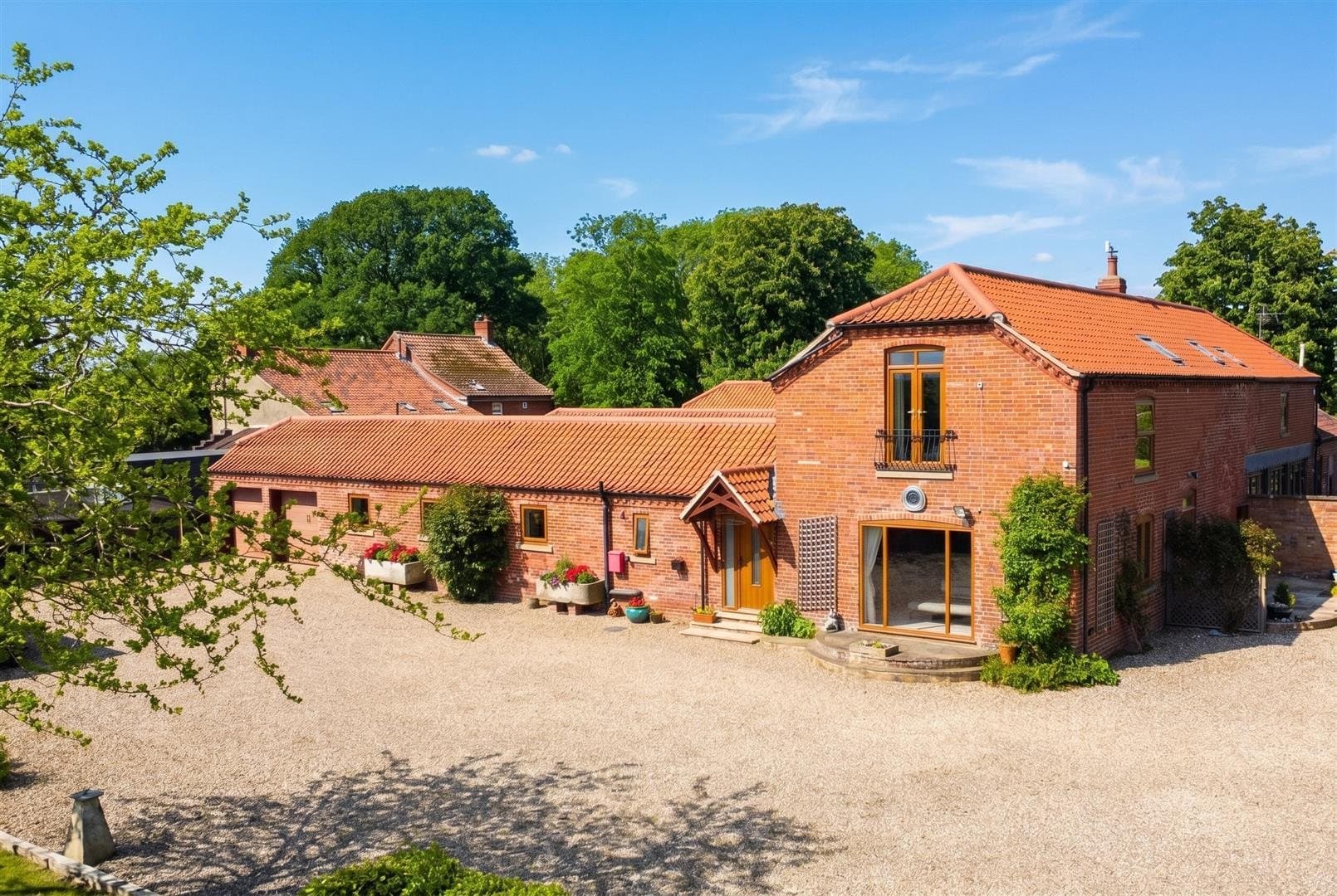 A converted brick barn and its gravelled yard in Fulbeck
