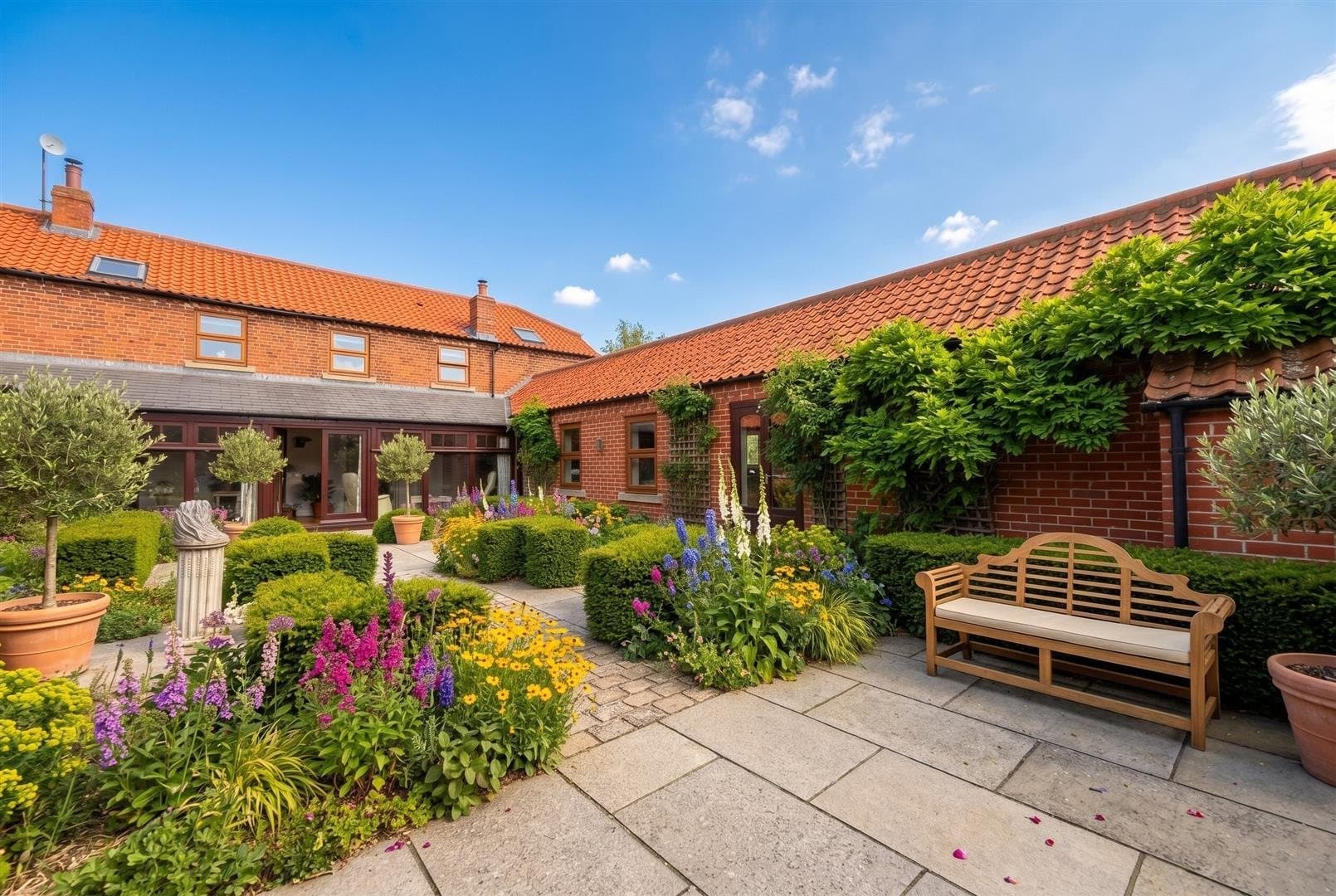 A walled courtyard garden in flower beside a converted barn in Fulbeck