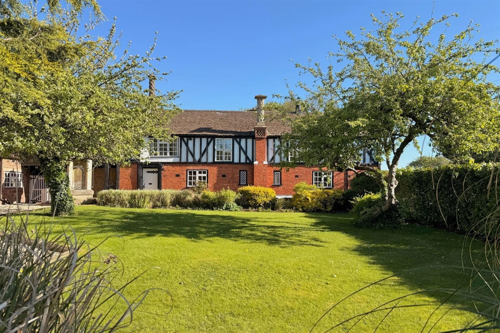 A period house in Harlaxton seen across its lawn and orchard