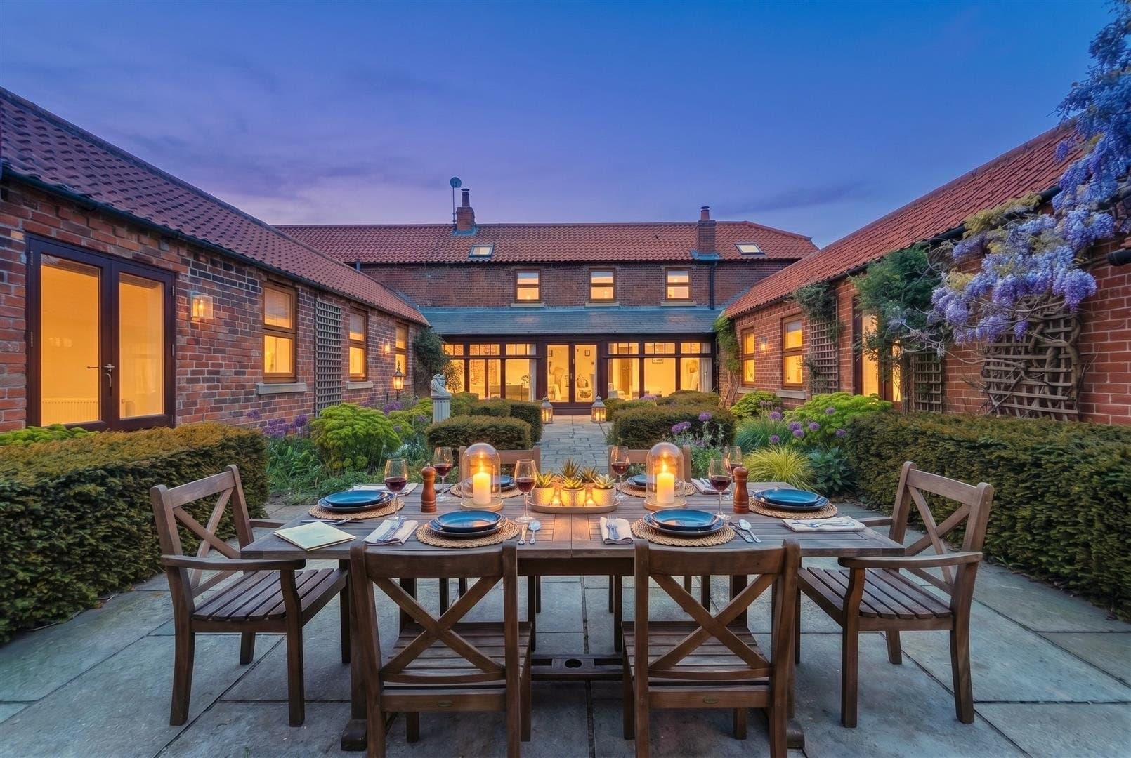 The barn conversion at Fulbeck, its courtyard lit at dusk